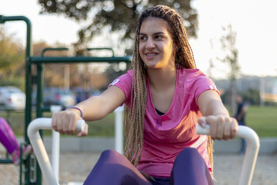 Teen girl using equipment outdoor in the communication with the workout, healthy lifestyle