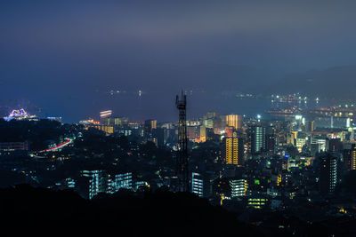 High angle view of illuminated buildings against sky at night