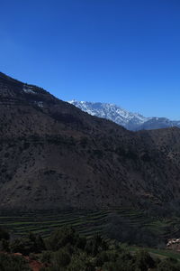 Scenic view of mountains against clear blue sky