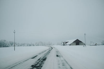 Snow covered field against clear sky