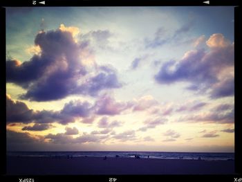 Scenic view of sea against cloudy sky at sunset