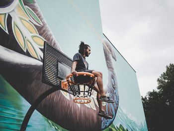 Low angle view of man sitting on bicycle