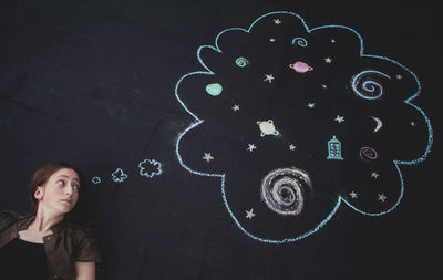 Portrait of woman standing against wall