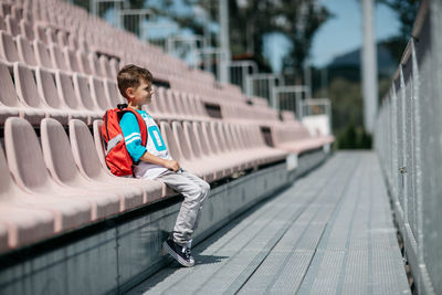 Boy sitting on chair at stadium