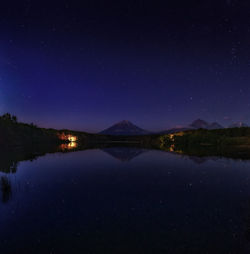 Scenic view of lake against sky at night