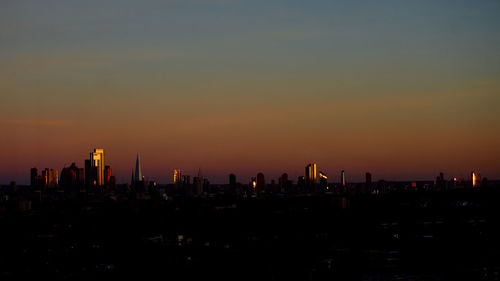 Silhouette buildings against sky during sunset