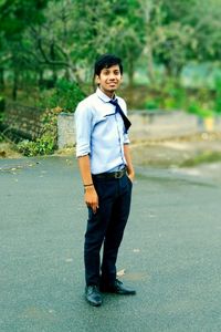 Portrait of young man standing on road