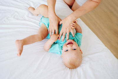 Low section of woman lying on bed at home