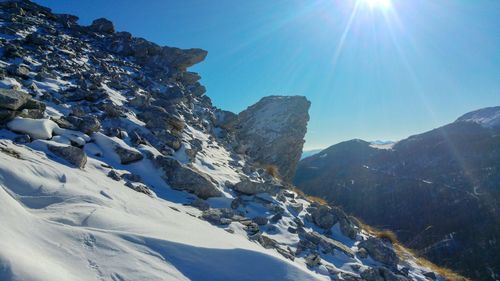 Scenic view of snowcapped mountains against sky on sunny day