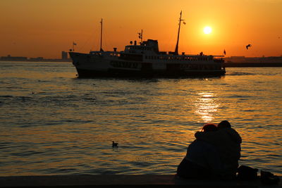 Silhouette boat in sea against sky during sunset