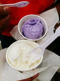 Close-up of hand holding ice cream on table