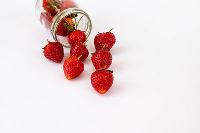 High angle view of strawberries in jar against white background