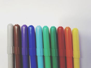 Close-up of colored pencils over white background