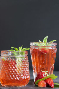 Fruits in glass jar against black background