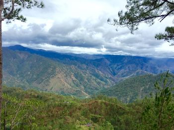 Scenic view of mountains against cloudy sky