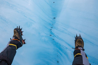 Low section of man ice climbing