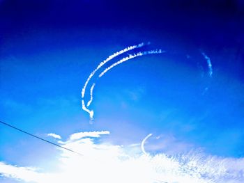 Low angle view of vapor trail against blue sky