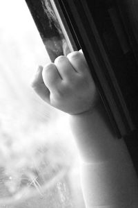 Close-up of hands against window