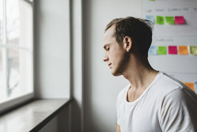 Side view of businessman by window in creative office