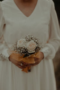 Midsection of woman holding rose bouquet