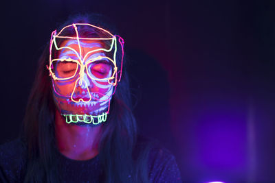 Close-up of woman with light painting in dark