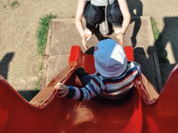 High angle view of child sliding towards mother in playground