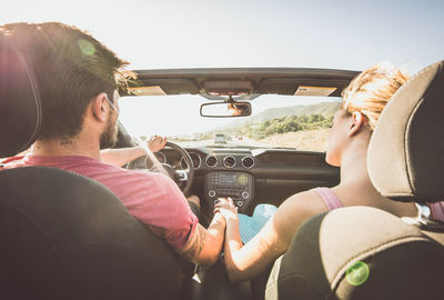 Rear view of couple sitting in car