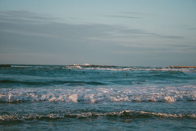 People swimming in sea against sky