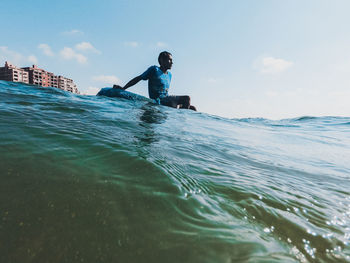 Man swimming in sea against sky