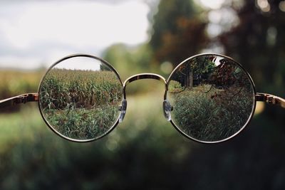 Close-up of eyeglasses against grassy field