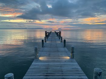 Pier over sea against sky during sunset