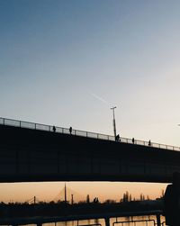 Low angle view of silhouette bridge against clear sky