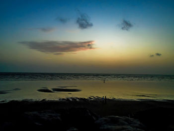 Scenic view of beach against sky during sunset