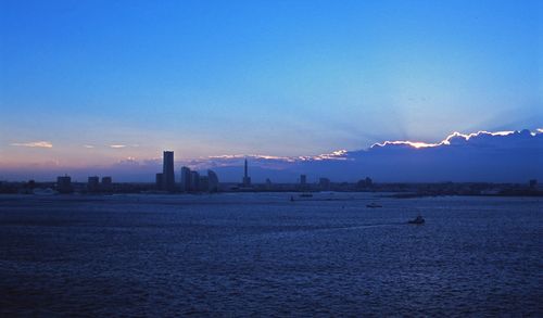 City by sea against sky during sunset