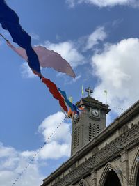 Low angle view of flags hanging on building against sky