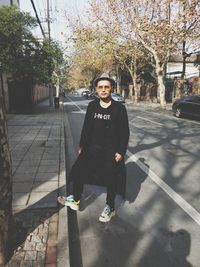 Portrait of smiling woman standing against tree