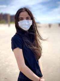 Portrait of young woman standing at beach