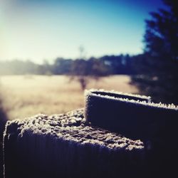 Close-up of snow on field against sky