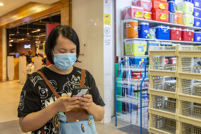 Woman wearing mask using mobile phone