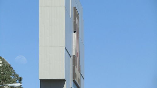 High section of modern building against blue sky