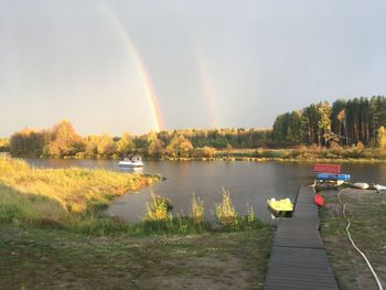 Scenic view of rainbow over lake against sky