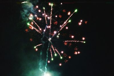 Low angle view of fireworks display at night