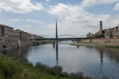 Bridge over river against buildings in city