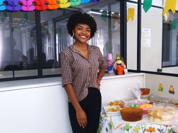 Portrait of a smiling woman standing by food