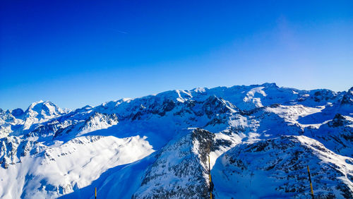 Scenic view of snowcapped mountains against clear blue sky
