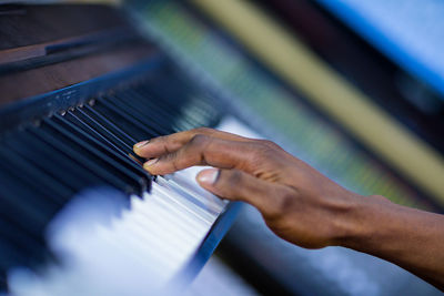 Cropped hand of woman playing piano