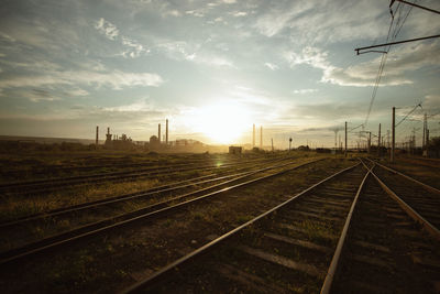 Railroad tracks against sky during sunset