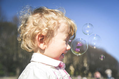 Cute boy with bubbles outdoors