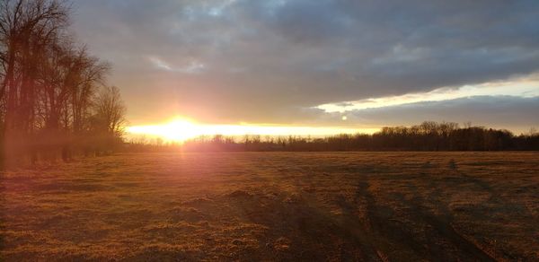Scenic view of field against sky during sunset