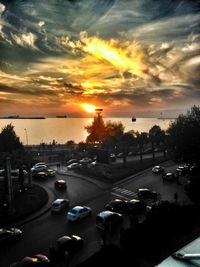 Cars on road against sky during sunset